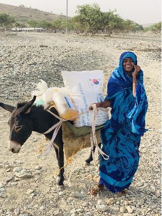 WFP를 통해 한국 쌀 원조를 받고 환하게 웃는 에리트리아 난민 케디아 (2021). 사진=농식품부